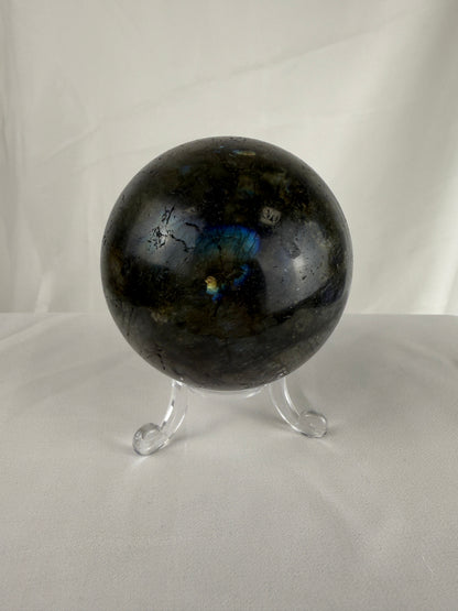 Labradorite crystal sphere on a stand against a white background